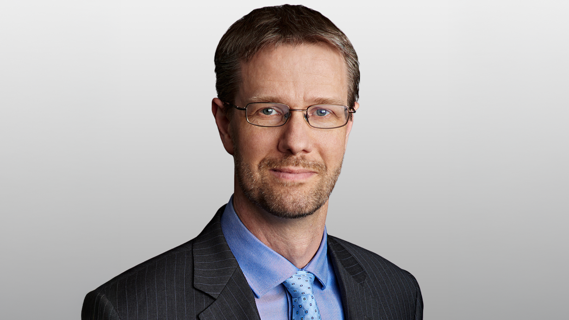 Michael Hatcher's headshot features a man in glasses, wearing a suit and tie.