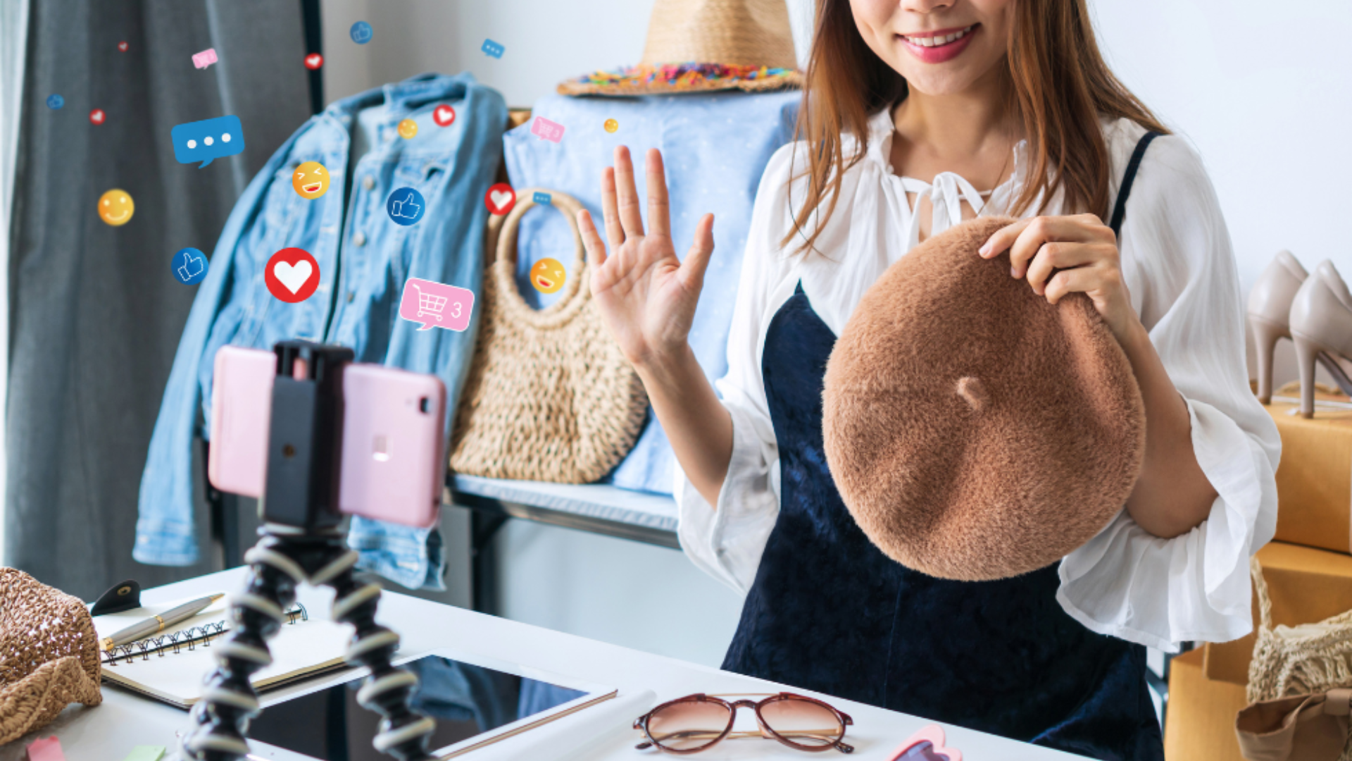 An influencer holds up a hat while doing a live stream show.