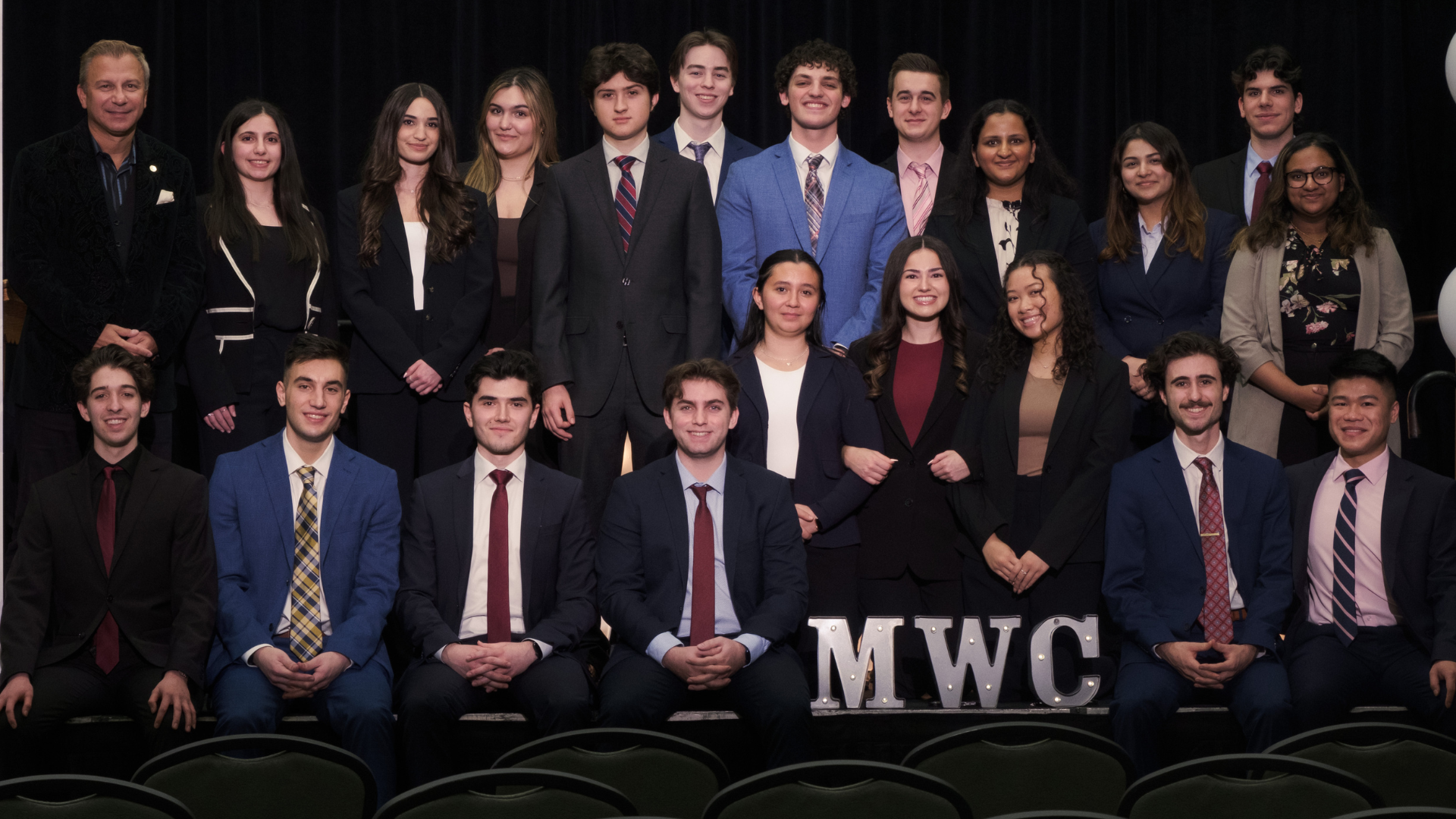 A group photo of young McMaster World Congress attendees dressed in suits and ties.