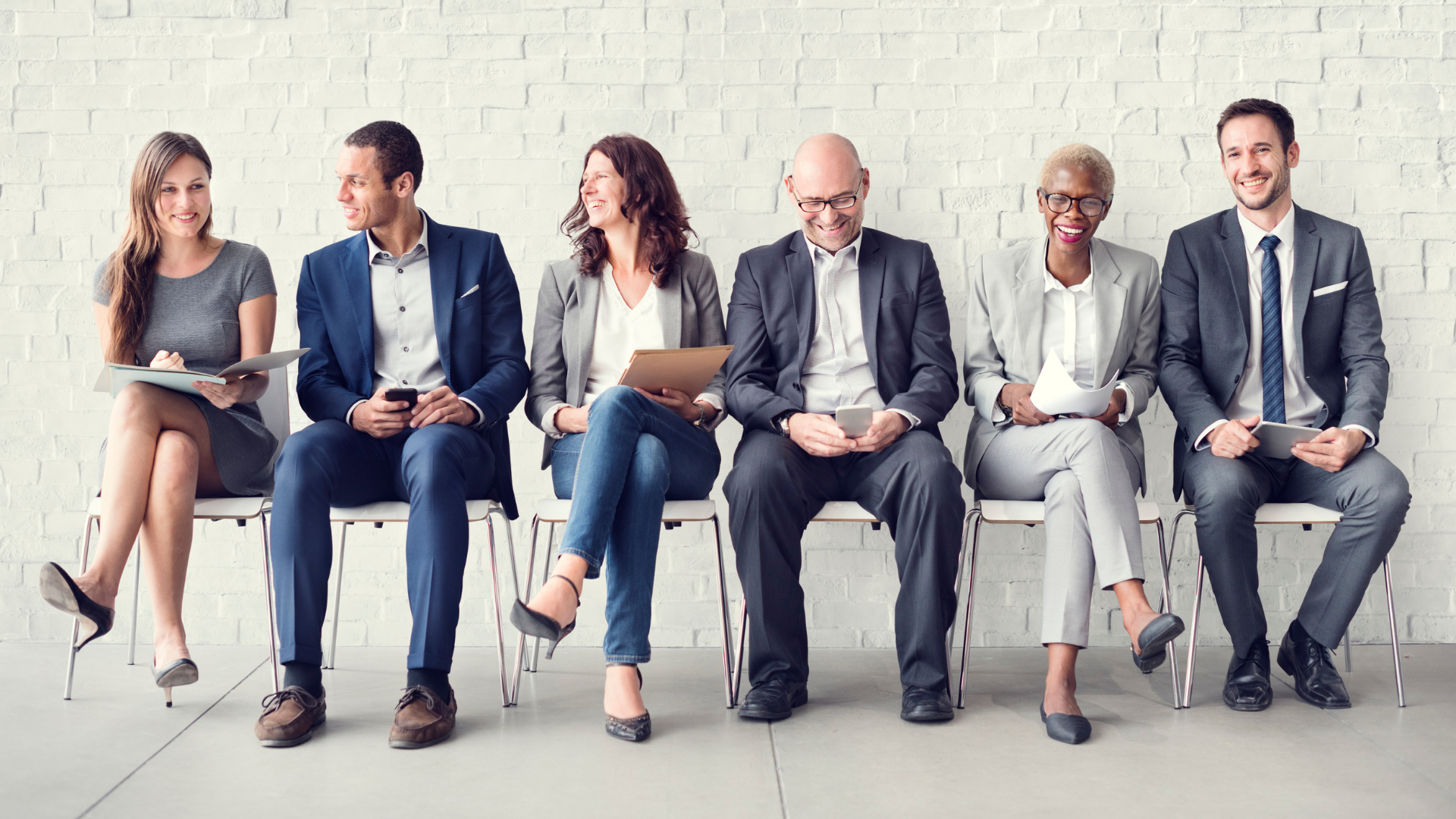 A diverse group of business professionals seated on chairs, engaged in discussion and collaboration in a modern office setting.