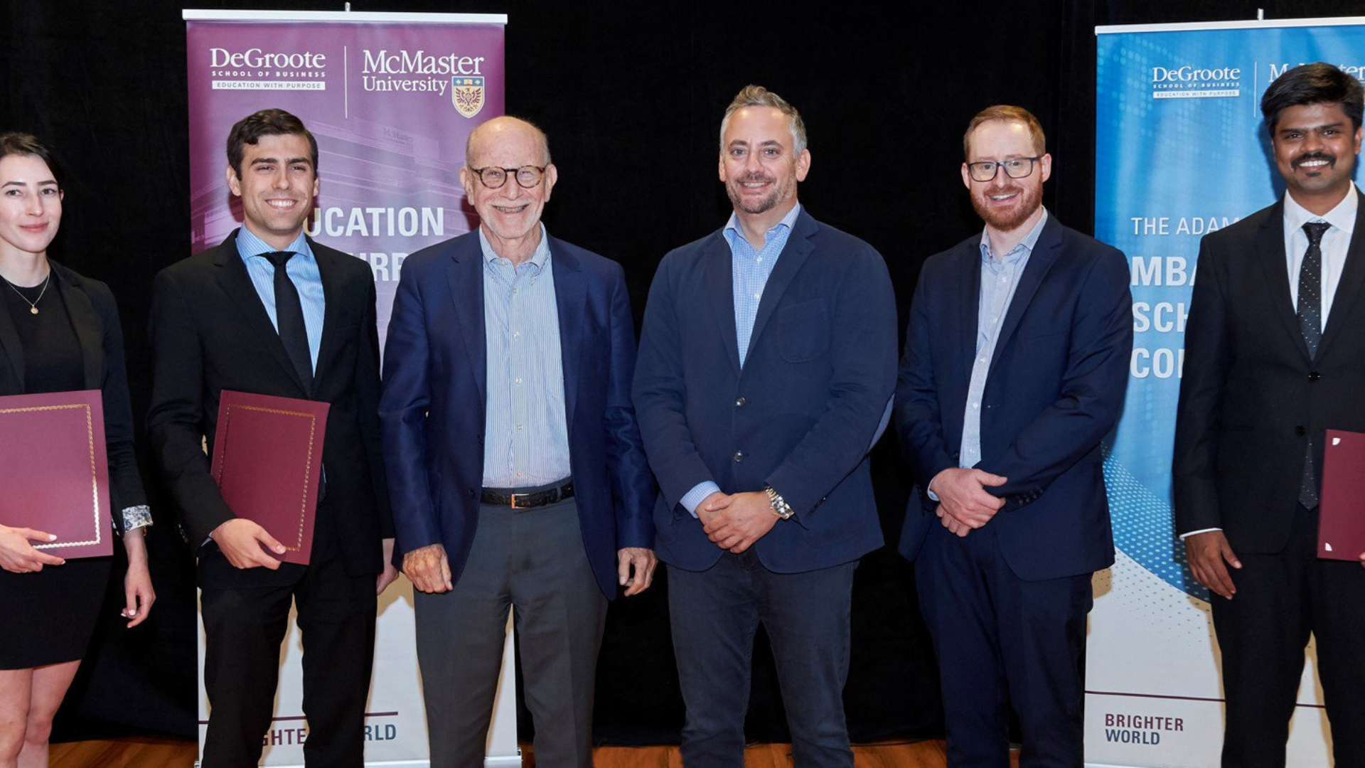 six individuals in formal attire, three proudly display their certificates from the Adam Felesky MBA scholarship competition.