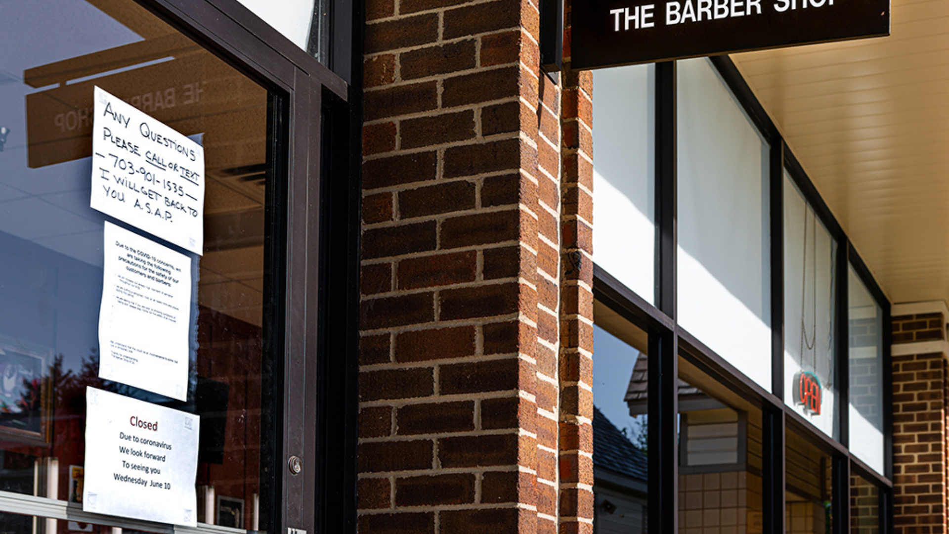 A sign on a barber shop indicating that the establishment is currently closed for business.