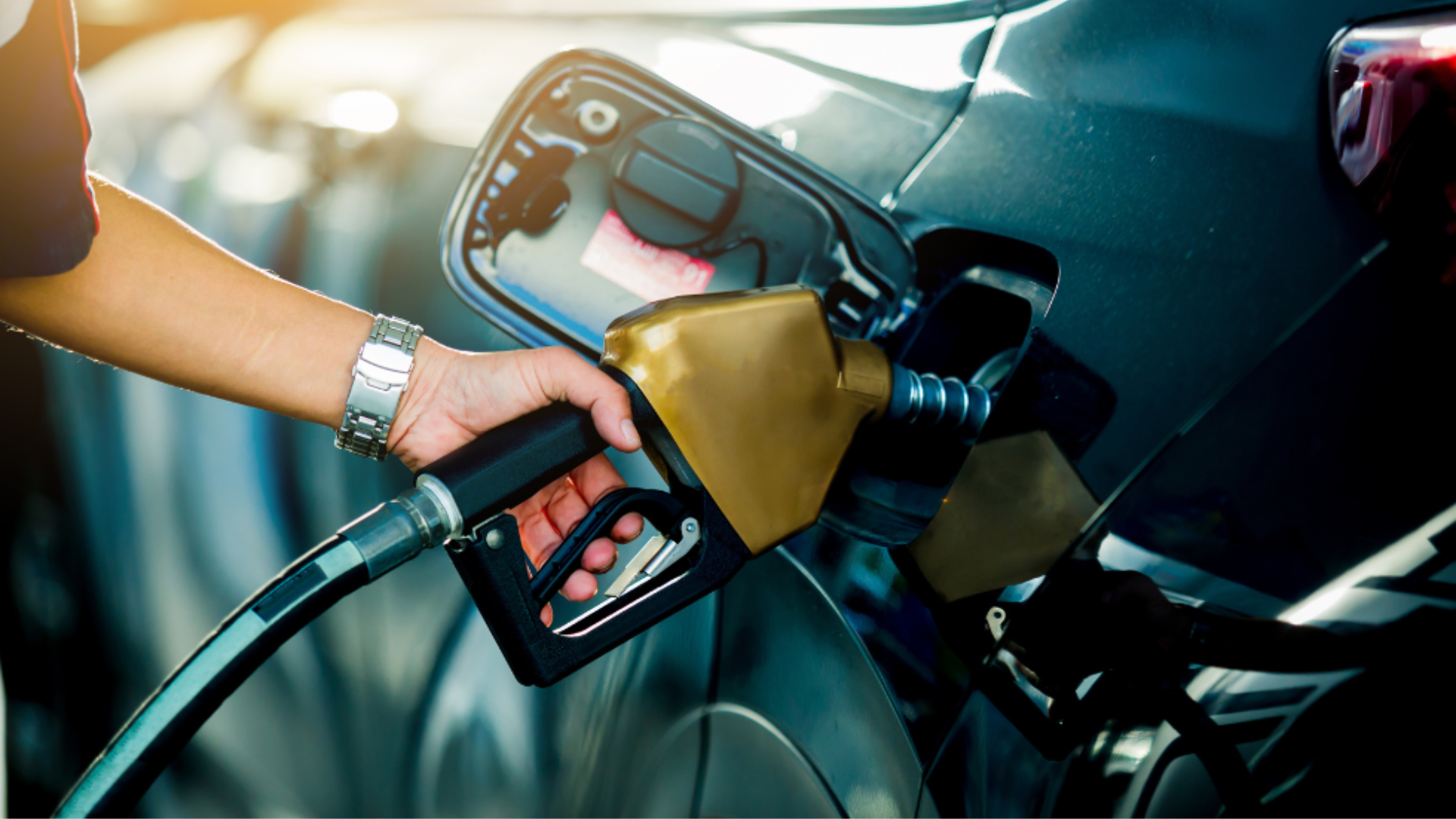 An individual is filling their car with gasoline at a service station.