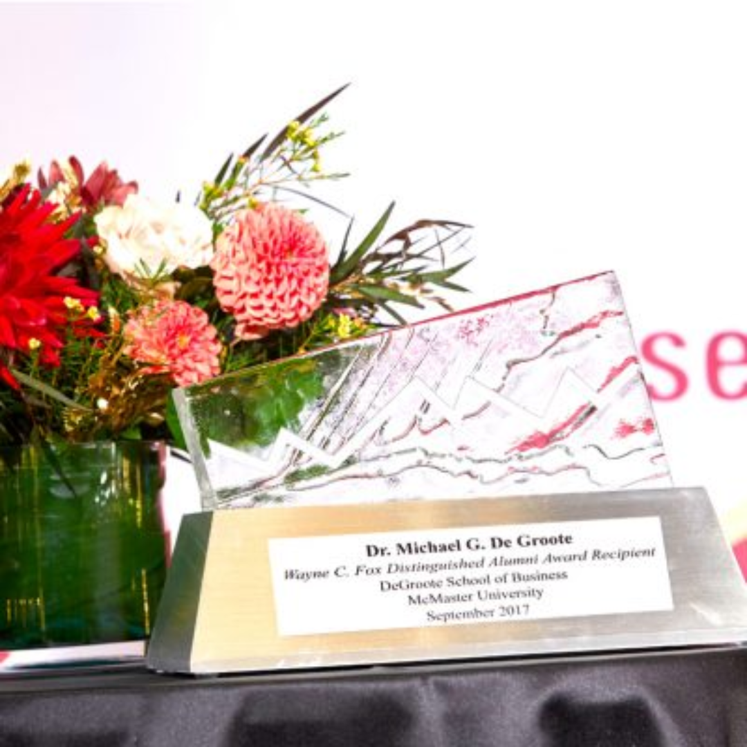 A glass trophy adorned with flowers, representing the Wayne C. Fox Distinguished Alumni Award recognition.