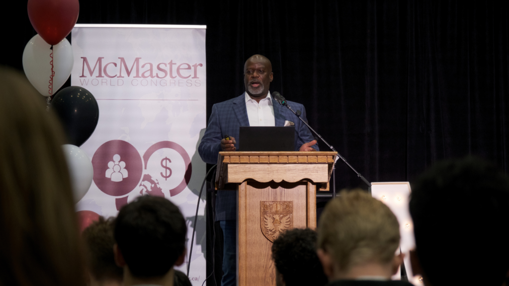 Dennis Mitchell delivers a speech at a podium.