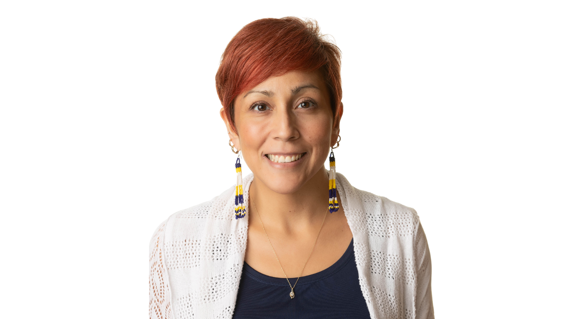 Amy Montour, a woman with vibrant red hair and blue, white, and yellow earrings, smiles radiantly