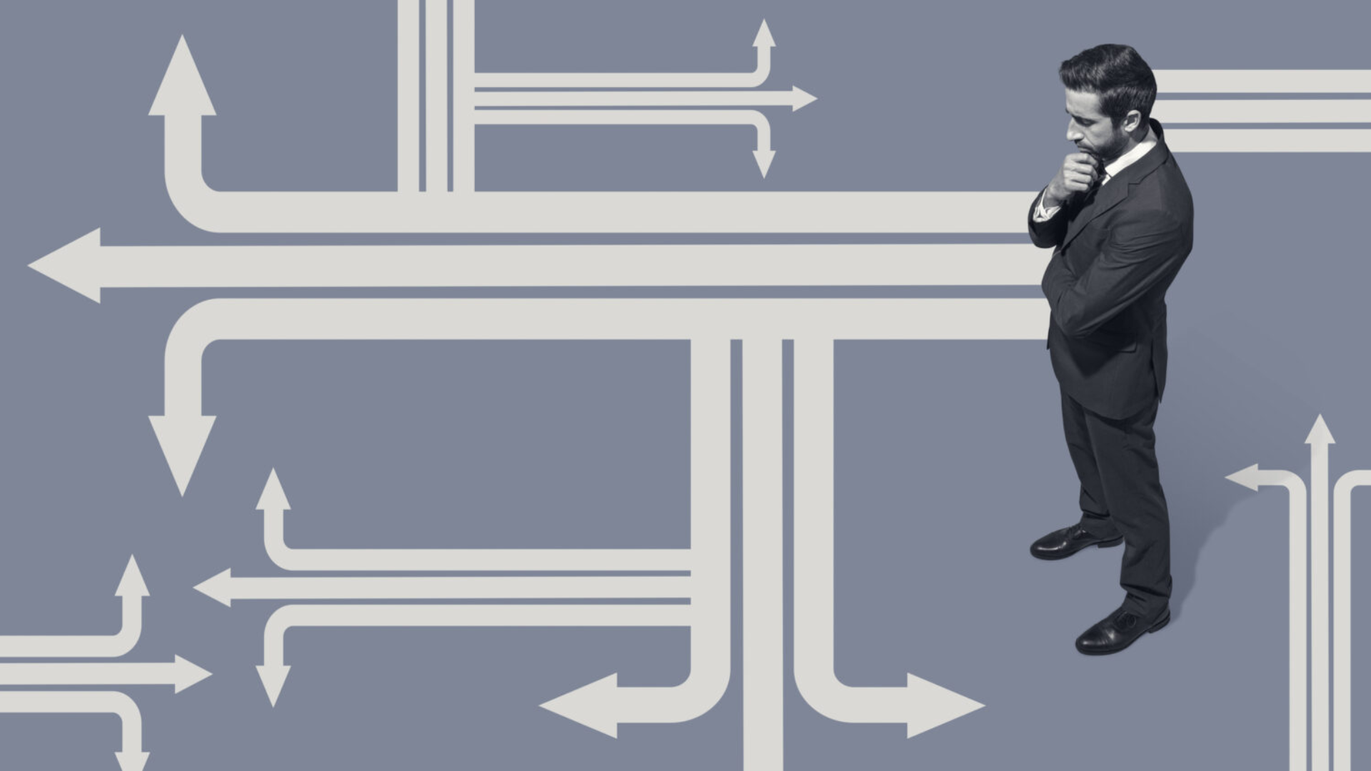 A man in a suit stands confidently before directional arrows, symbolizing guidance in the future of work.