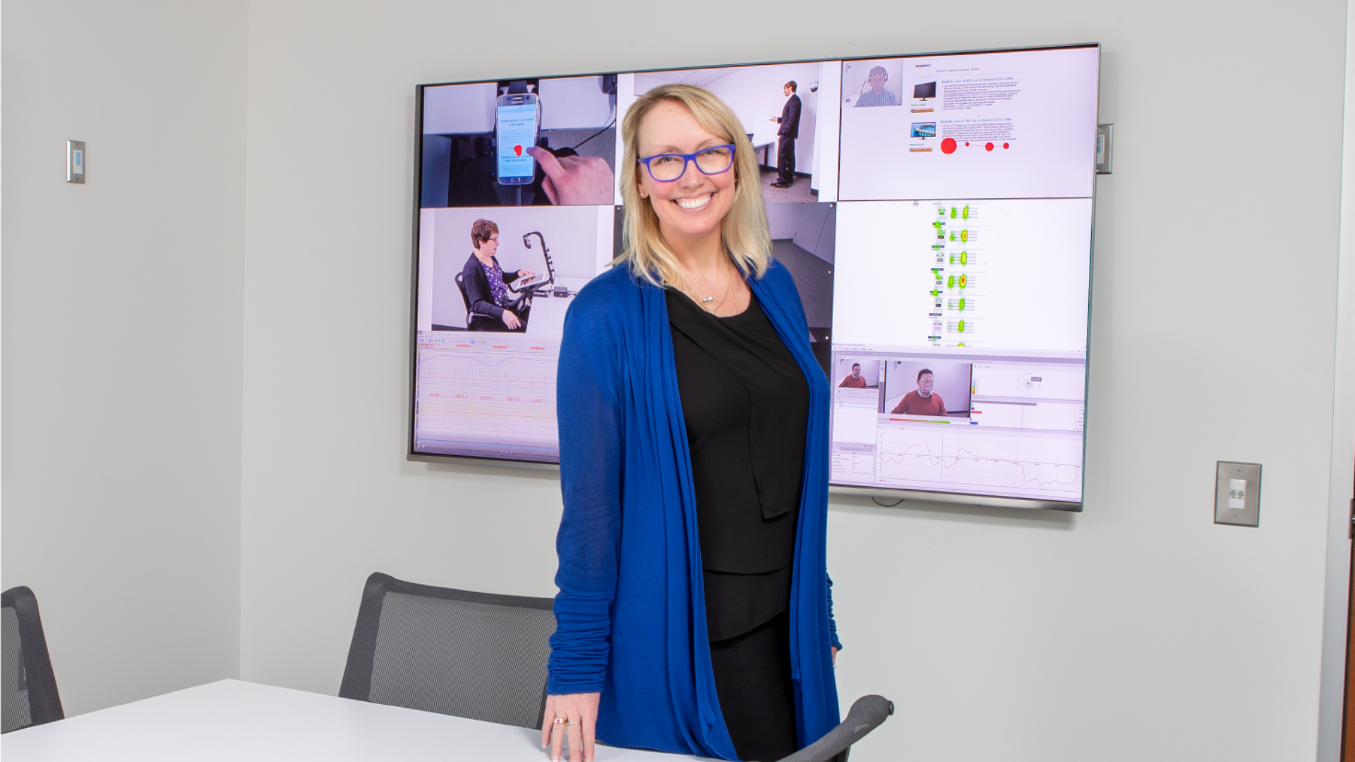 Milena Head smiles while standing in front of a large screen, showcasing her confidence and engagement with the audience.