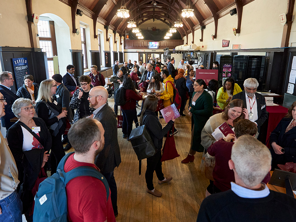 A large crowd gathers in Alumni Memorial Hall for a DeGroote faculty and research event