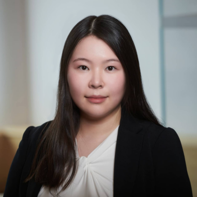 Helen Zhu, an Asian woman in a business suit, smiles confidently.