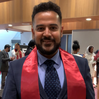 Jay Bhatia, smiling in a suit and tie.