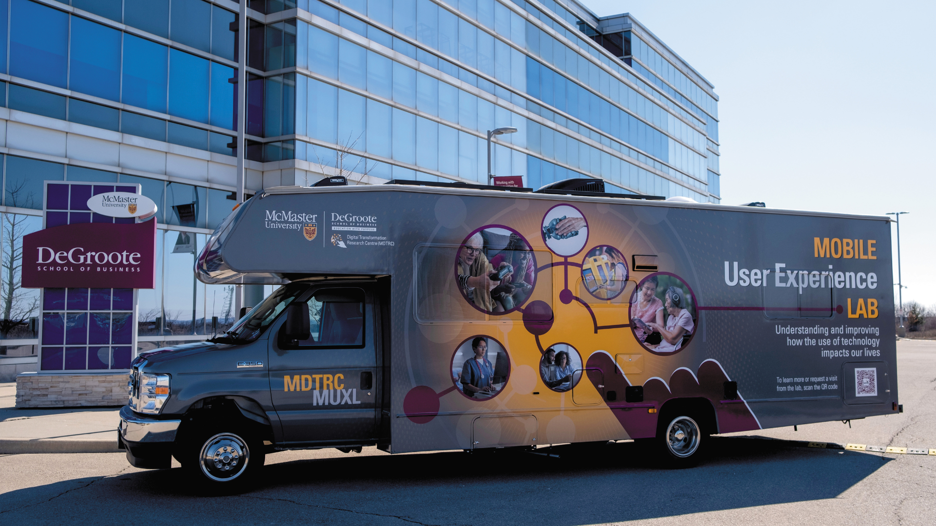 A mobile lab truck from the McMaster Digital Transformation Research Centre parked outside the Ron Joyce Centre building.