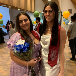 Valentina Acevedo and Anastasia Kountouris smile together proudly displaying their graduation sashes.