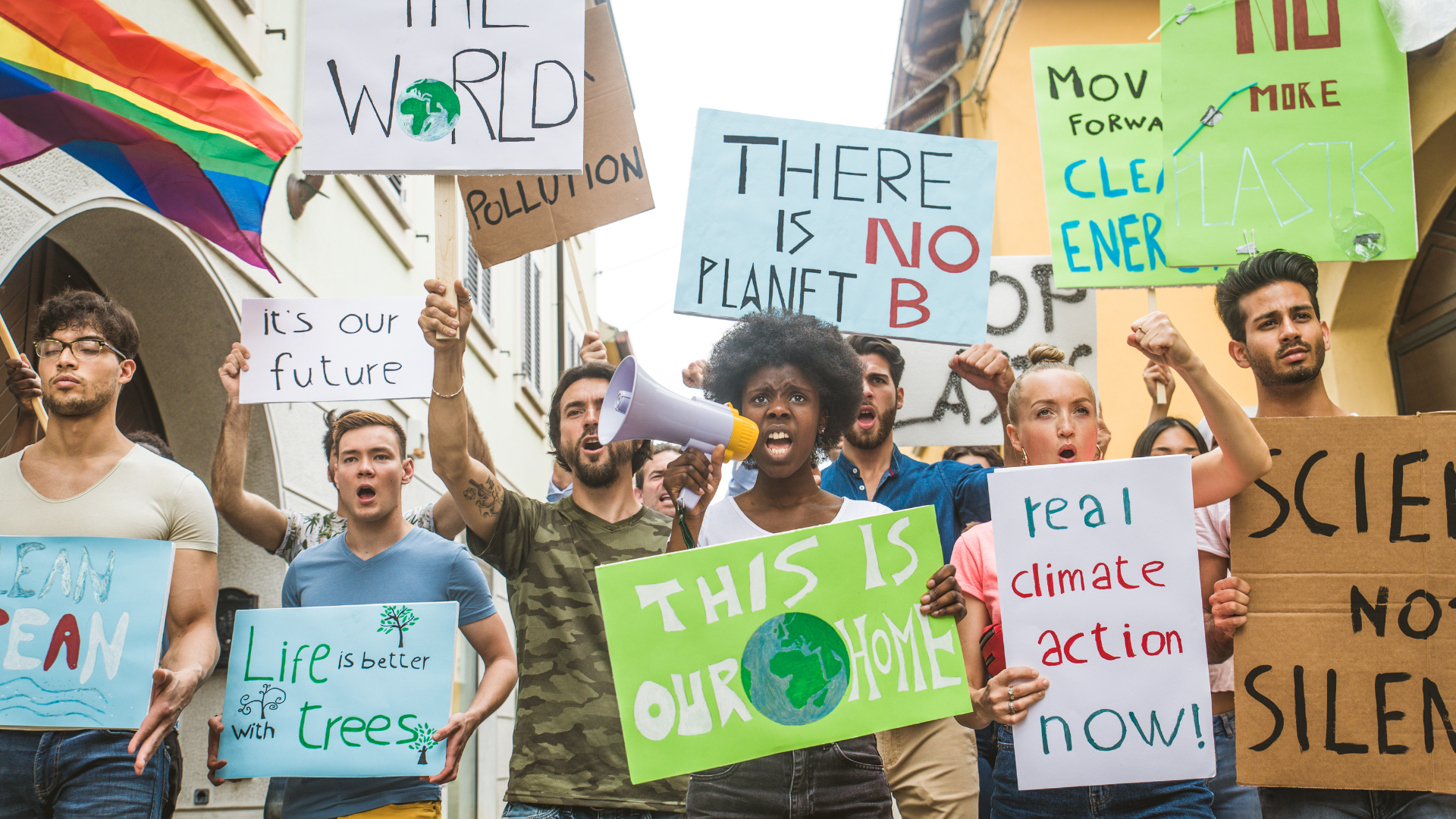 A group of social climate activists in the street, holding signs and chanting.