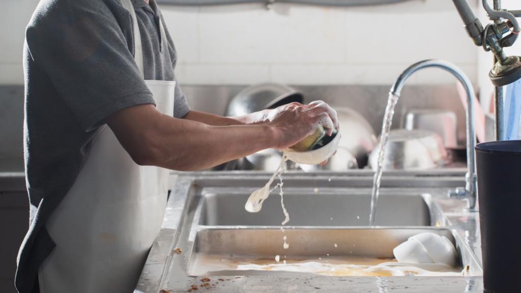 A restaurant worker washing dishes