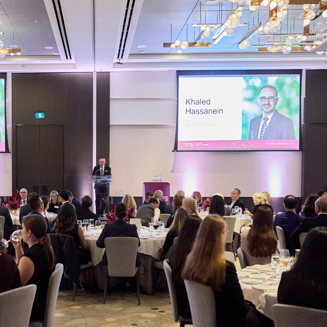 A spacious room with attendees seated, attentively watching Khaled Hassanein presenting during the DeGroote Accolades Awards ceremony.