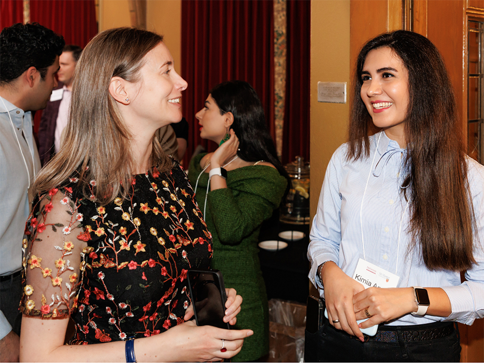 Two women engaged in conversation at the PhD 45th Anniversary Celebration event.