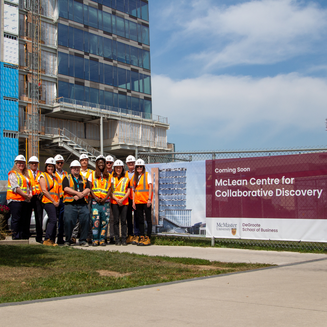 Group of people wearing safety vests standing beside a 