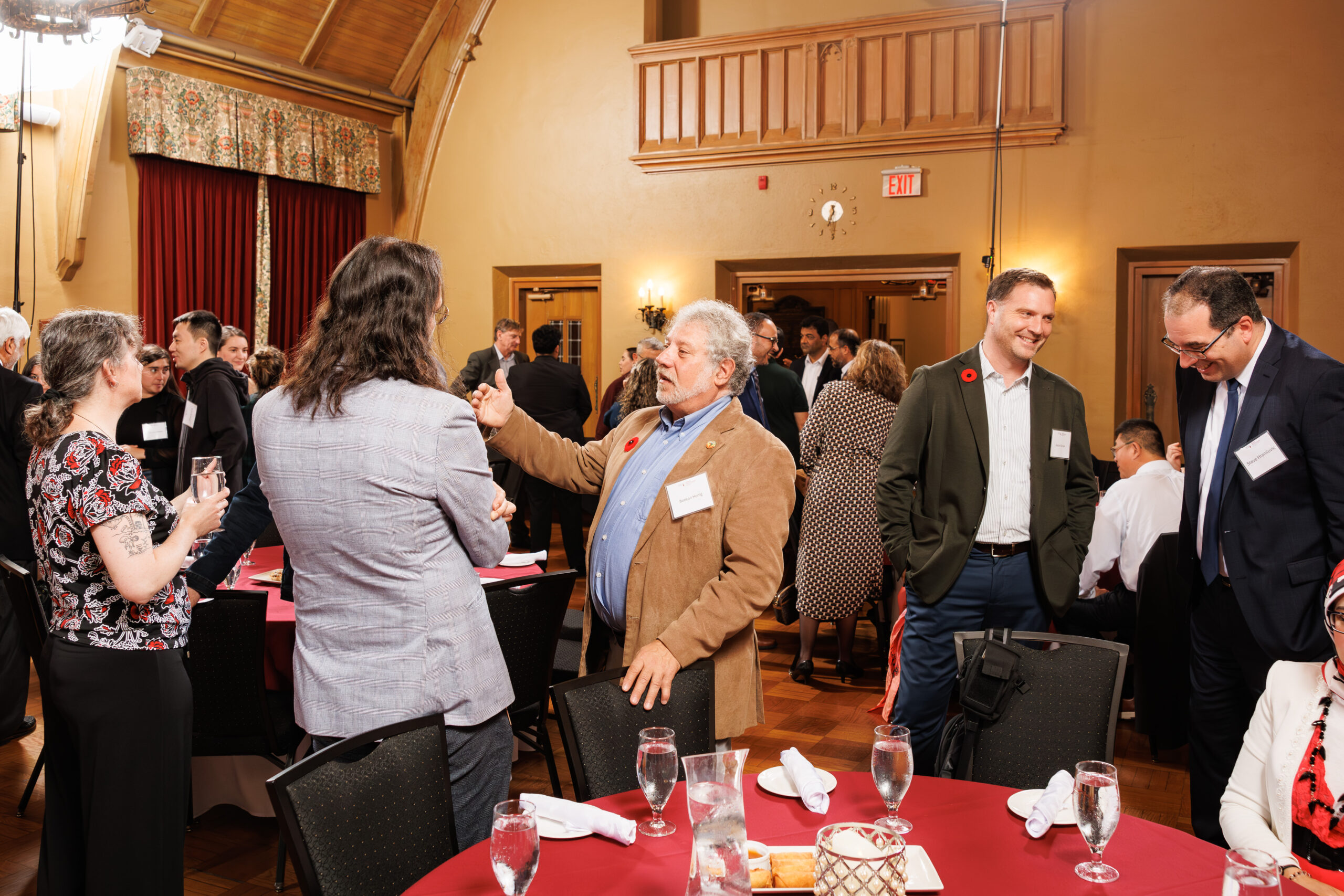 A group of DeGroote researchers and PhD students networking in a spacious dining hall.