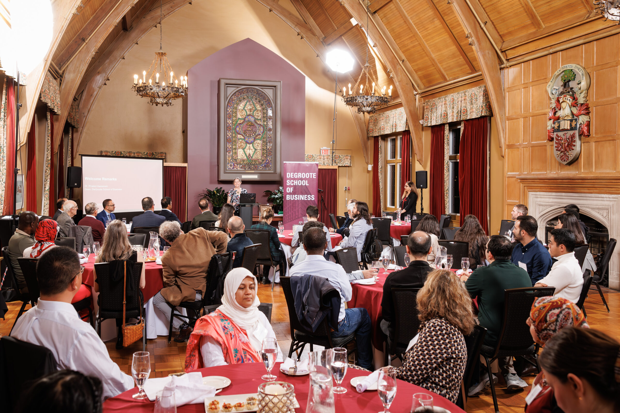 Attendees at the DeGroote PhD Awards Night seated in a dining hall, focused on the speaker at the podium.