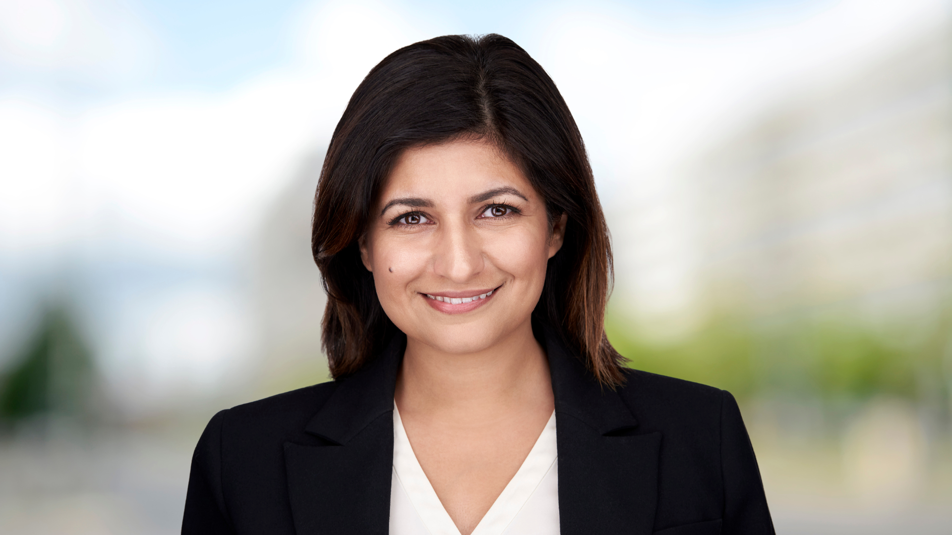 Maryam Haghighi, dressed in a black jacket, smiling.