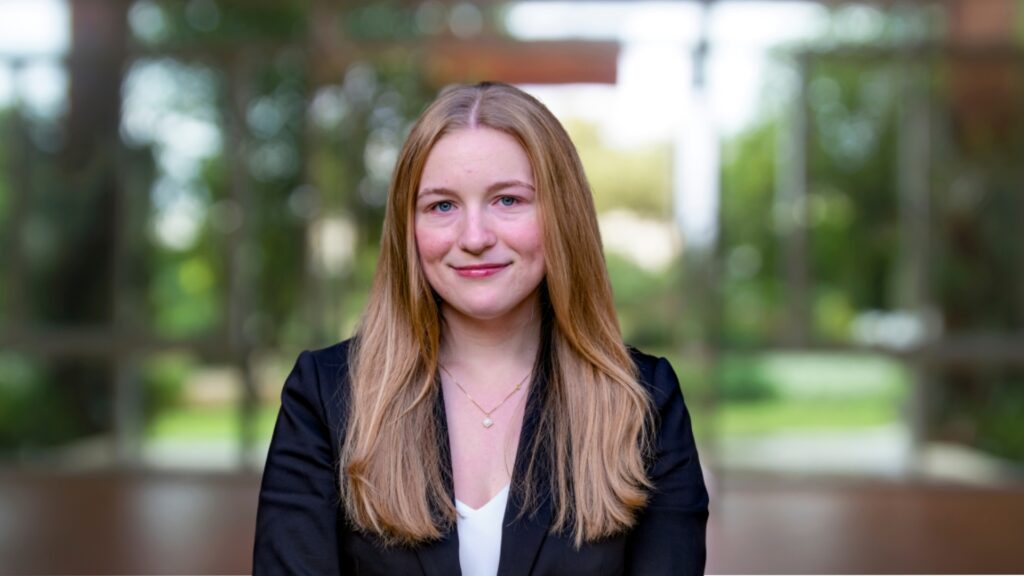 Headshot of Kellie Stevenson, smiling woman with long blonde hair, wearing a black blazer